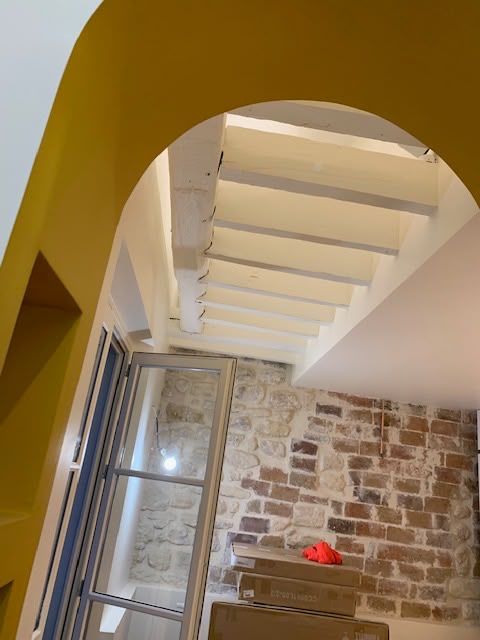 Arche jaune et mur de briques après rénovation